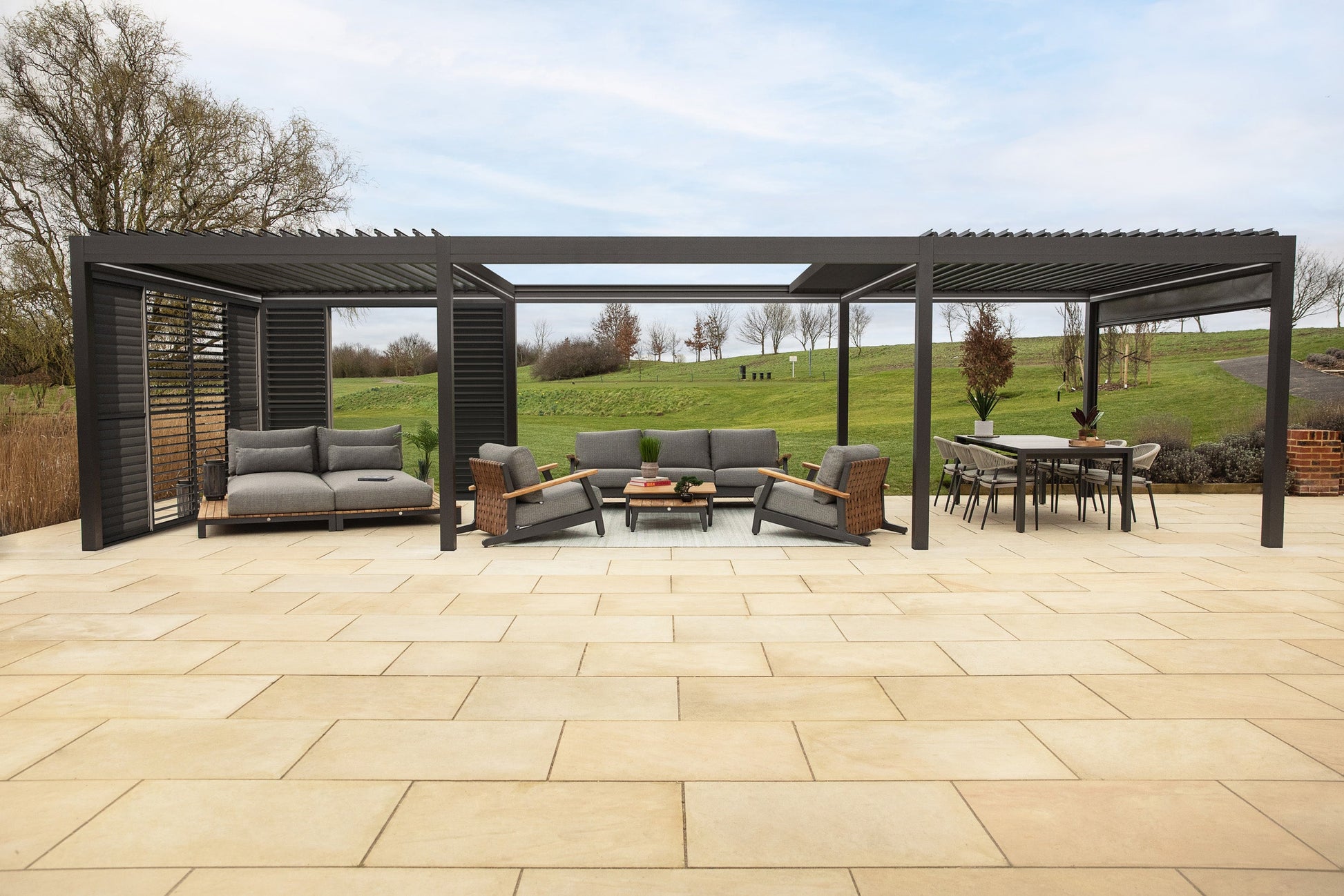 Outdoor patio with pergola, furniture, and a view of a field.